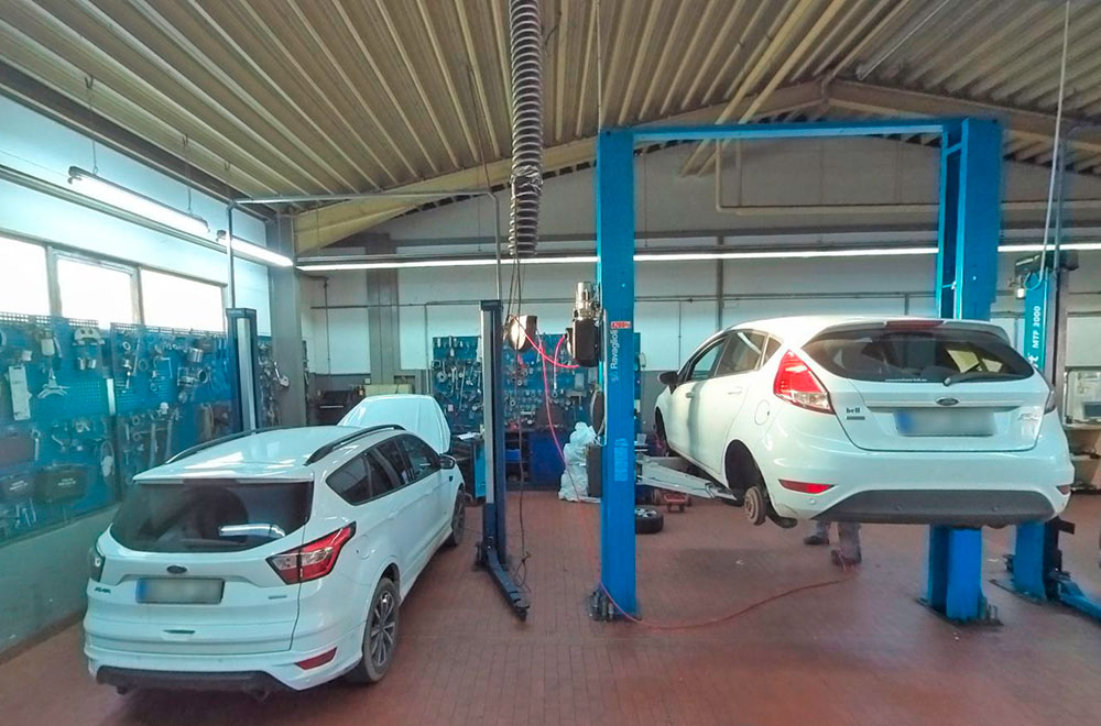 Blick in die Werkstatt mit zwei Fahrzeugen zur Reparatur und Service